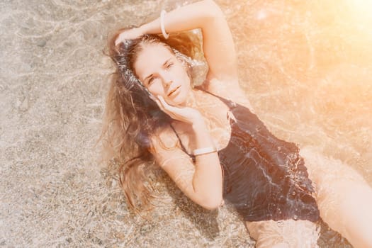 Woman travel sea. Young Happy woman in a long red dress posing on a beach near the sea on background of volcanic rocks, like in Iceland, sharing travel adventure journey