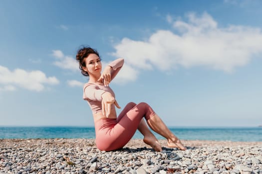 Young woman with long hair in white swimsuit and boho style braclets practicing outdoors on yoga mat by the sea on a sunset. Women's yoga fitness routine. Healthy lifestyle, harmony and meditation