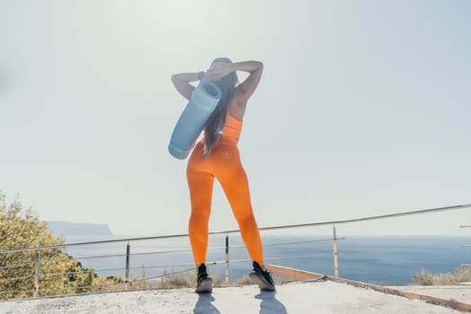 Fitness woman sea. Outdoor workout on yoga mat in park near to ocean beach. Female fitness pilates yoga routine concept. Healthy lifestyle. Happy fit woman exercising with rubber band in park.