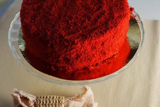 Red velvet cake takes center stage, served on a transparent glass dish