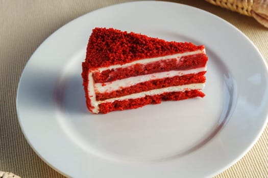 Piece of red velvet cake rests on a pristine white plate, inviting you to savor its rich flavors with every bite.