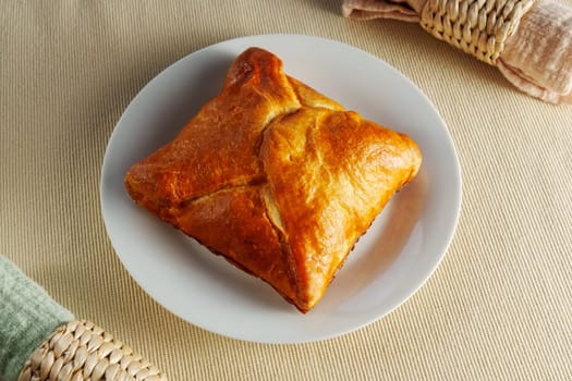 Delicate Delights: A Flaky Puff Pastry Placed Elegantly on a Gleaming White Plate