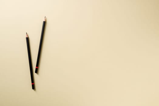 Pencil with black paint and a red stripe on a yellow background