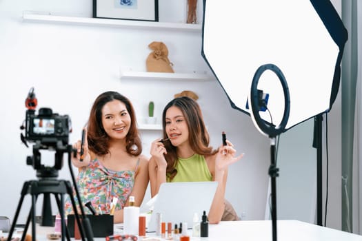 Asian Woman influencer shoot live streaming vlog video review makeup uttermost social media or blog. Happy young girl with cosmetics studio lighting for marketing recording session broadcasting online