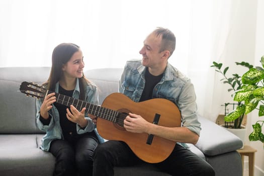 Happy family Father and daughter playing guitar. Father's day. High quality photo