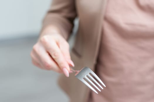 Fork in a hand on a white background isolation. High quality photo