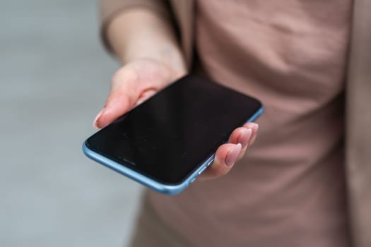 A businesswoman is holding mobile phone - on white background. High quality photo