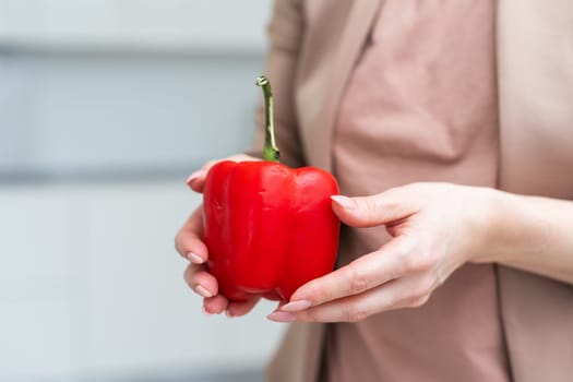 hand holding paprika or red sweet pepper isolated on white background. Fresh bell pepper or bulgarian pepper in male hairy hand as organic harvest concept. High quality photo