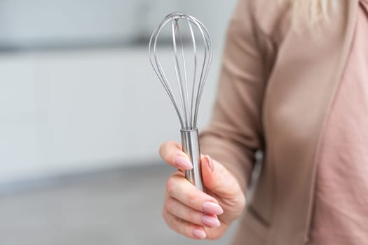 Female holding in hand whisk isolated on white background. Clipping Path. Full depth of field. High quality photo