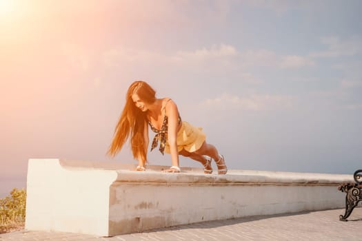 Woman park yoga. Side view of free calm bliss satisfied woman with long hair standing in morning park with yoga position against of sky by the sea. Healthy lifestyle outdoors in park, fitness concept