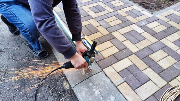 Man working with electric grinder tool on Steel beam. Electric grinding. Remove rust. Cutting of metal beam