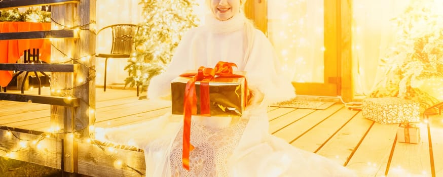 A woman in a white dress holding a gift box.