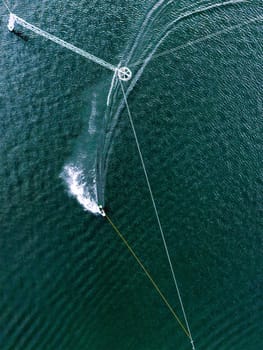 Aerial wakeboarding. Top view of awakeboard rider in wake cable park. Water sport background. Drone top down shot