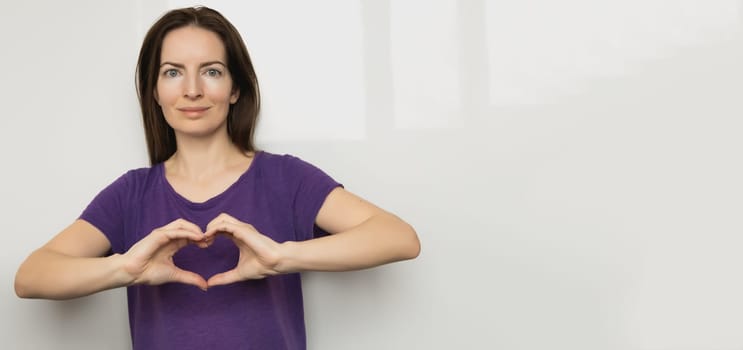 Inspire inclusion. Zoomers symbolize love. Woman finger heart dressed purple t-shirt. Hand showing heart. International Women's Day 2024 banner, InspireInclusion