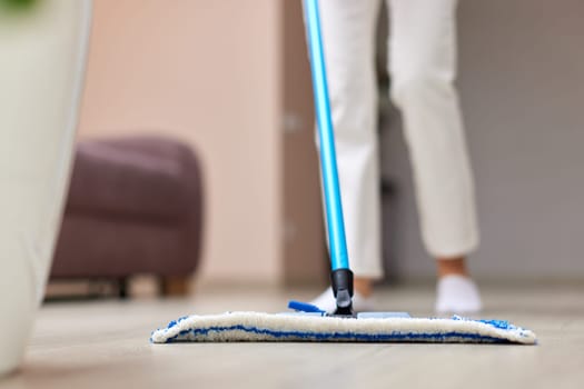 young woman cleaning and mopping floor at living room, daily housekeeping , close-up