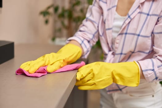 young woman in gloves cleaning and wiping table with microfiber cloth. chores at home. Housekeeping