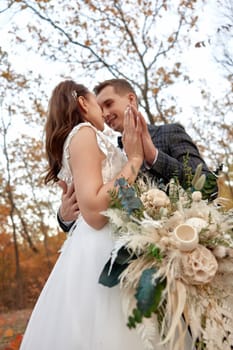 beautiful sensual bride in white wedding dress and groom standing outdoor on natural background