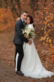 beautiful bride in white wedding dress and groom standing in countryside