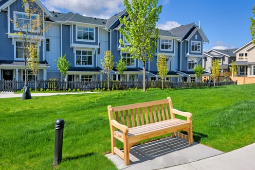 Bright wooden bench in a small recreational park of the residential block