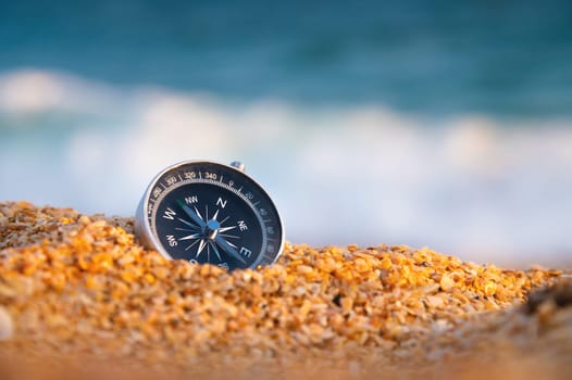 compass on sea sand and place for text. close up of navigation device on sandy beach without people, top view.