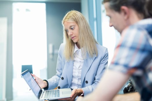 Business meeting. Client consulting. Confident business woman, real estate agent, financial advisor explaining details of project or financial product to client in office