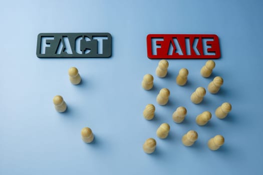 Plates of fact and fake words with figures who chose them. Disinformation and propaganda concept.