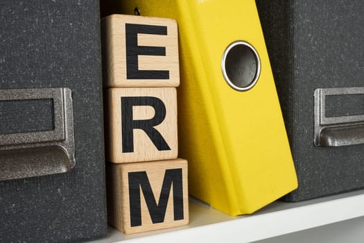 Shelf with folders and wooden cubes ERM Enterprise risk management.