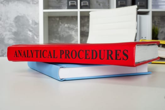 Book analytical procedures lies on the office table.