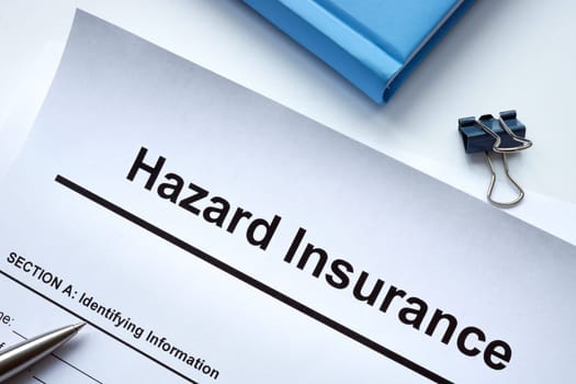 Hazard insurance policy form and a pen.