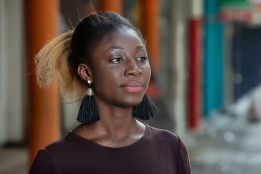 young girl standing in purple tee-shirt looking away.