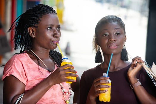 young girls shopping with bottles of juice in hand.