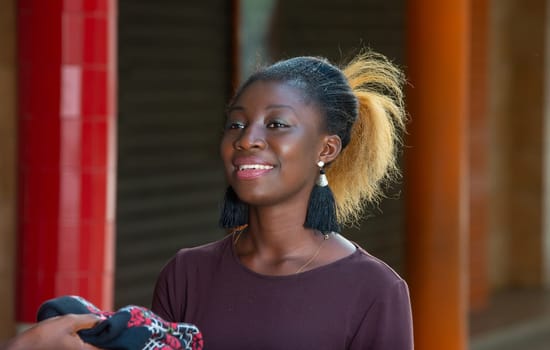 young girl standing outside looking at camera smiling.