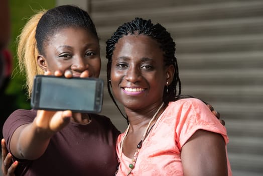 sitting girls showing the mobile phone screen smiling.