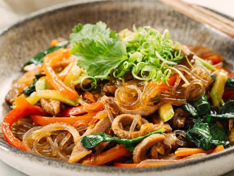 Asian noodles with meat and vegetables. Stir fry noodles with vegetables and beef, pork or chicken. Plate of asian buckwheat soba noodles with vegetables and chicken.