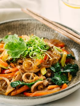 Asian noodles with meat and vegetables. Stir fry noodles with vegetables and beef, pork or chicken. Plate of asian buckwheat soba noodles with vegetables and chicken.