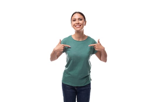 charming cute friendly slender young brunette woman dressed in a green t-shirt points her index finger to the side.
