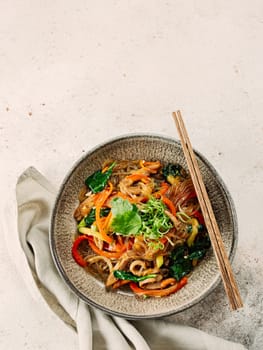 Asian noodles with meat and vegetables. Stir fry noodles with vegetables and beef, pork or chicken. Plate of asian buckwheat soba noodles with vegetables and chicken.