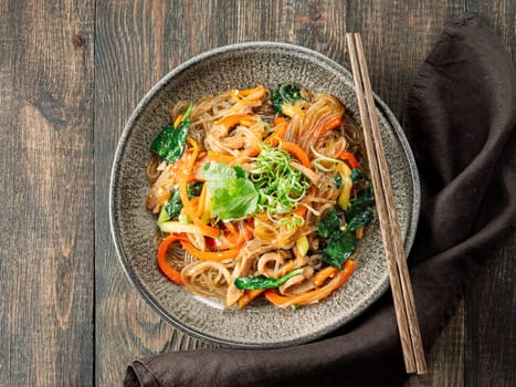 Asian noodles with meat and vegetables. Stir fry noodles with vegetables and beef, pork or chicken. Plate of asian buckwheat soba noodles with vegetables and chicken.