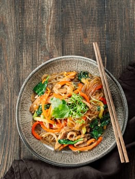 Asian noodles with meat and vegetables. Stir fry noodles with vegetables and beef, pork or chicken. Plate of asian buckwheat soba noodles with vegetables and chicken.