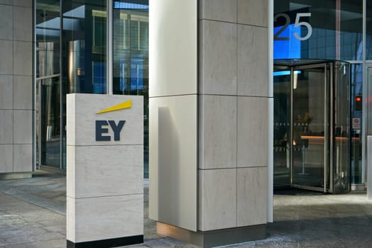 London, United Kingdom - February 03, 2019: Blue and yellow EY signage at entrance to their office in Canary Wharf. It is UK professional services company, one of big 4 accounting firms