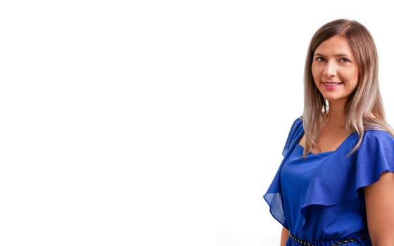 Young brunette woman in blue dress looking into camera, smiling, white background and space for text left side