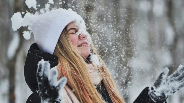 The girl throws snow in her face