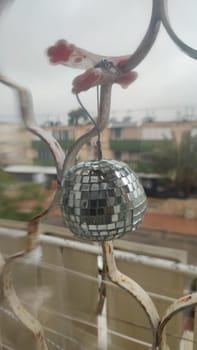 round shiny mirror ball hanging on the window, objects. High quality photo