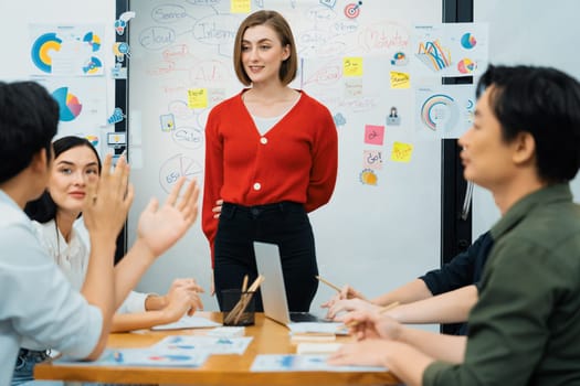 Professional attractive female leader presents creative marketing plan by using brainstorming mind mapping statistic graph and colorful sticky note at modern business meeting room. Immaculate.