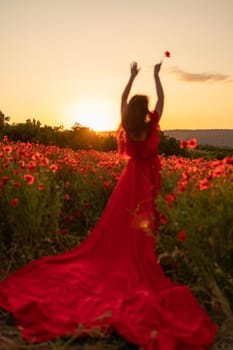 Woman poppy field red dress sunset. Happy woman in a long red dress in a beautiful large poppy field. Blond stands with her back posing on a large field of red poppies.