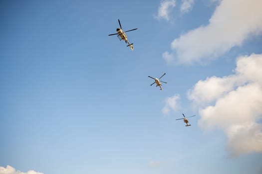 Helicopter in flight against blue sky. Modern rescue technology hovering with new engine. Pilot maneuvers small aircraft showcasing speed and rescue capabilities.