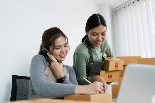 Asian woman write parcel box to prepare for delivery to customer. e-business concept.