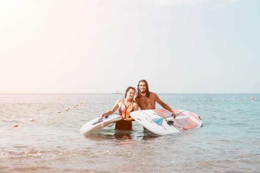 Woman man sea sup. Close up portrait of beautiful young caucasian woman with black hair and freckles looking at camera and smiling. Cute woman portrait in a pink bikini posing on sup board in the sea