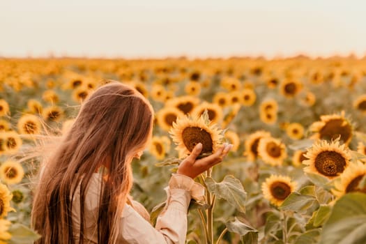 Woman in the sunflowers field. Summer time. Young beautiful woman standing in sunflower field.