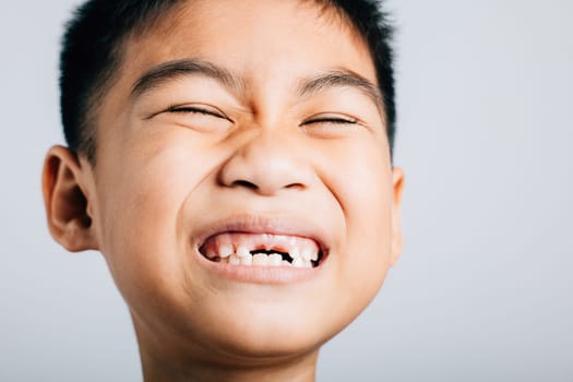 Smiling schoolboy tooth lost gap shows. Child isolated portrait on white. Joyful dental growth development. Children show teeth new gap, dentist problems. little boy no tooth